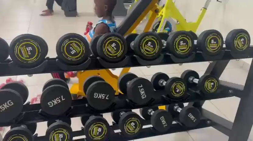 The gym's rack of black and yellow dumbbells labelled by weight